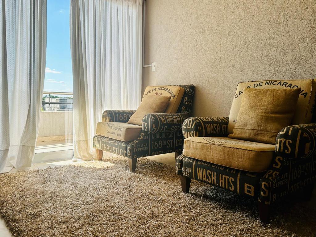 Una sala de estar con un sofá y una silla y una ventana. en depto 82, en Cañuelas