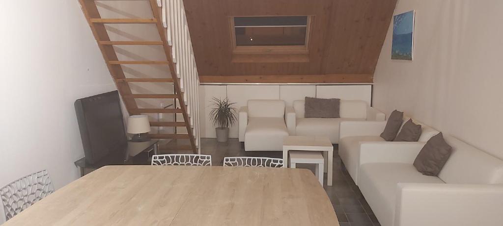 ein Wohnzimmer mit einer weißen Couch und einer Treppe in der Unterkunft Le Jardin d'Eden in Château-Thierry