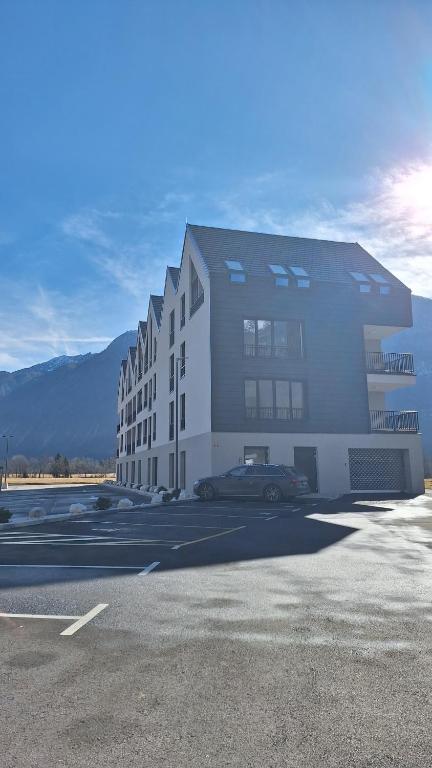a building with a car parked in a parking lot at Adventure Oasis Bovec in Bovec