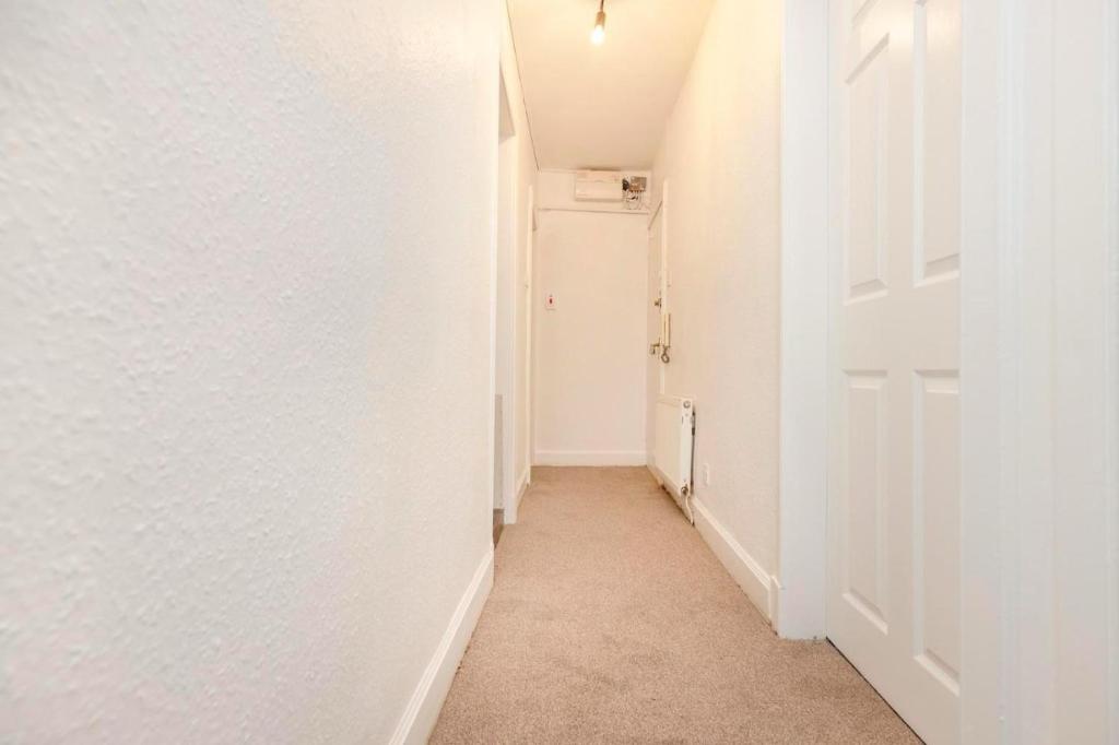 einen Flur mit weißen Wänden und einer weißen Tür in der Unterkunft Royal Mile Apartments in Edinburgh
