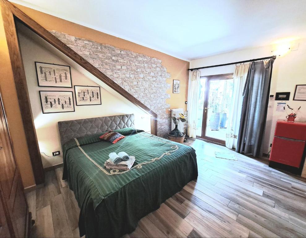 een slaapkamer met een bed met een groen dekbed bij MARCONI DEPENDANCE in Campi Bisenzio