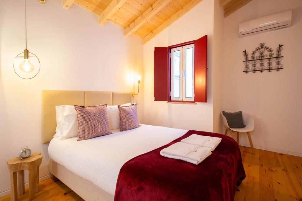 een slaapkamer met een groot wit bed in een kamer bij Casinha de Vide - Guest House in Castelo de Vide