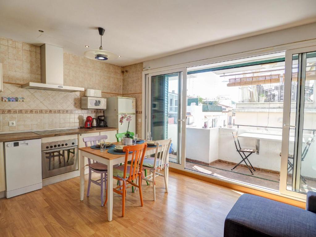 a kitchen and dining room with a table and chairs at Carmen Apartment by Hello Homes Sitges in Sitges
