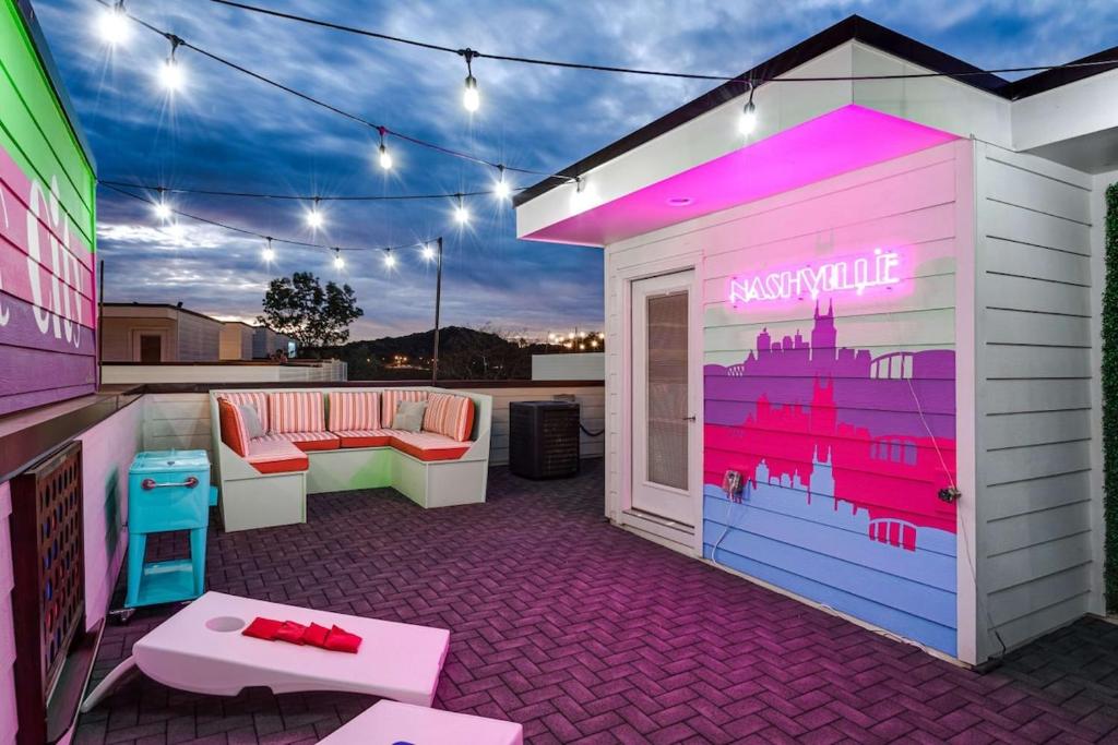 eine Dachterrasse mit einer Bar mit einer rosa und lila Wand in der Unterkunft New Dolly's Oasis 13Beds City Views Near Downtown in Nashville