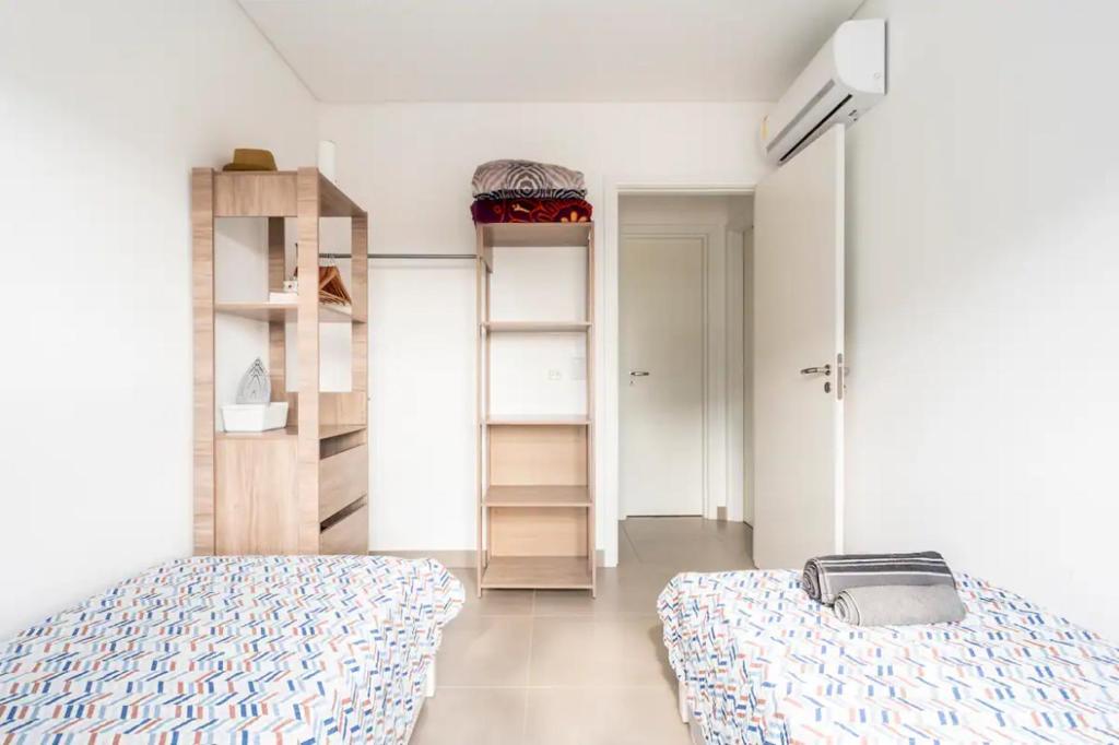 1 dormitorio con cama y estante para libros en Quarto+banheiro+Wi-Fi frente Floripa Shopping, en Florianópolis