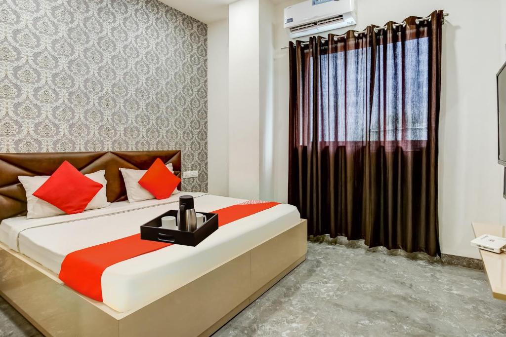 una camera da letto con un grande letto con cuscini rossi di OYO Flagship Hotel Jo Jo a Ludhiana