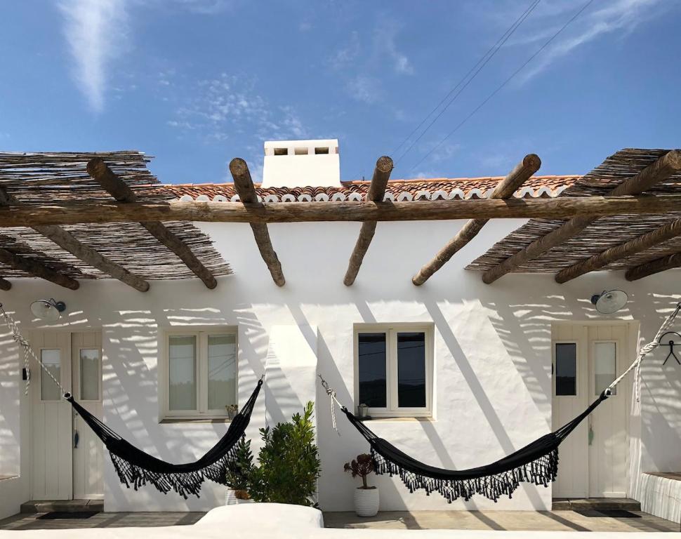 a white house with a hammock in front of it at Casas de Seixe in Baiona