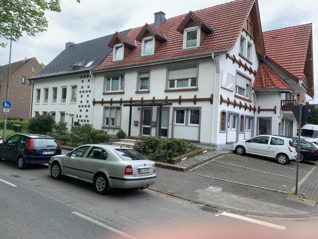 a white house with cars parked in front of it at KM Apparts Wesel 3 in Wesel