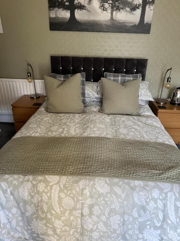 een groot bed met een witte sprei en kussens bij Wentworth guesthouse in Whitby