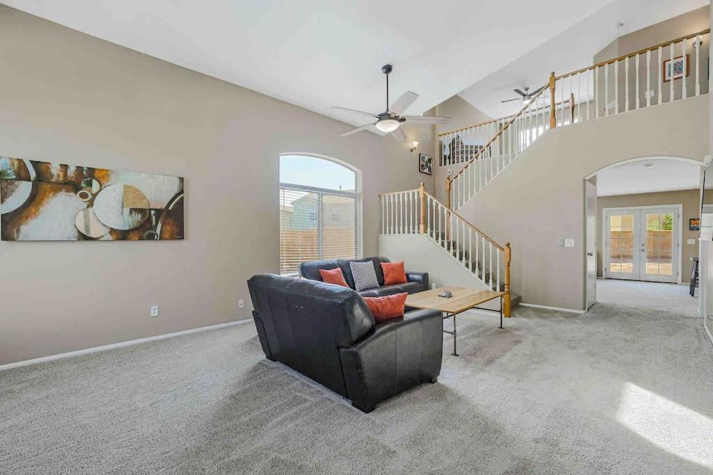 a living room with a couch and a staircase at Jill's Goodyear Getaway in Goodyear
