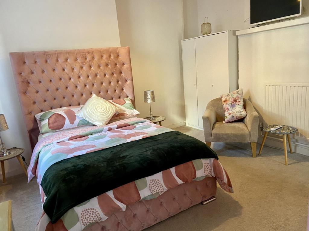- une chambre avec un grand lit et une chaise dans l'établissement The Rosefield, à Weymouth