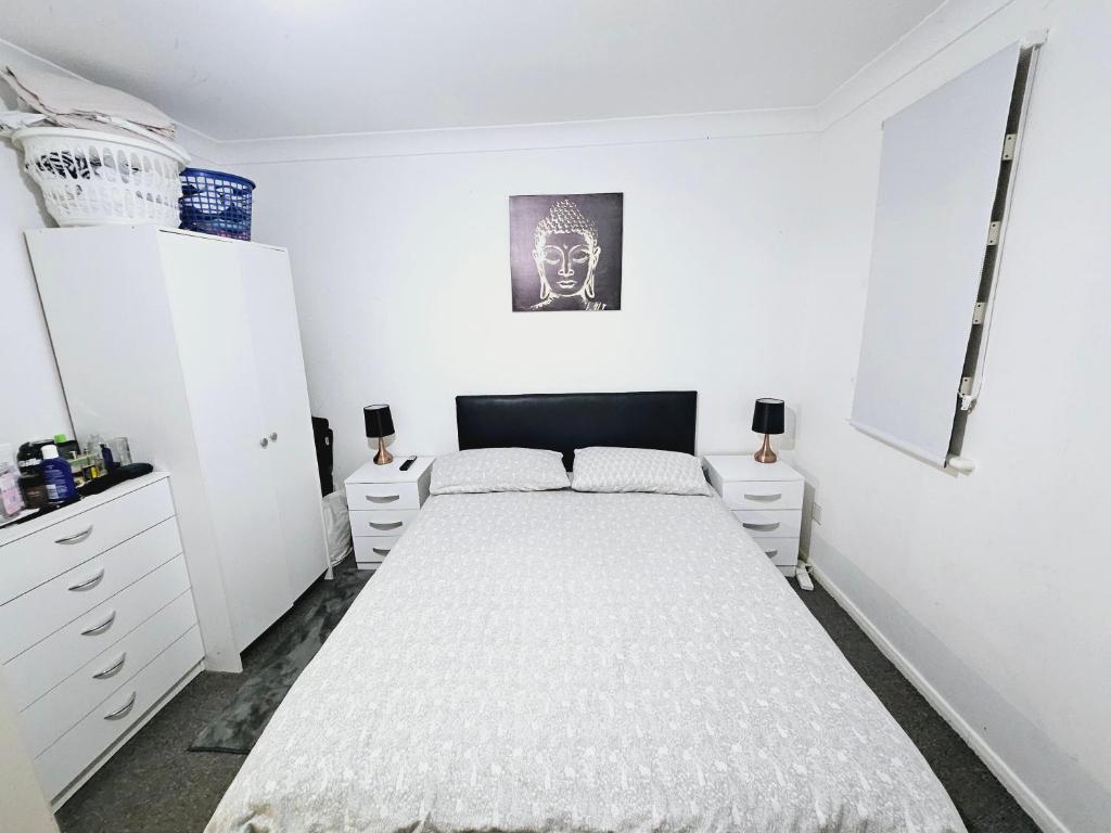 a white bedroom with a bed and white cabinets at Lovely Fully Furnished One Bed Flat To Let in Enfield Lock