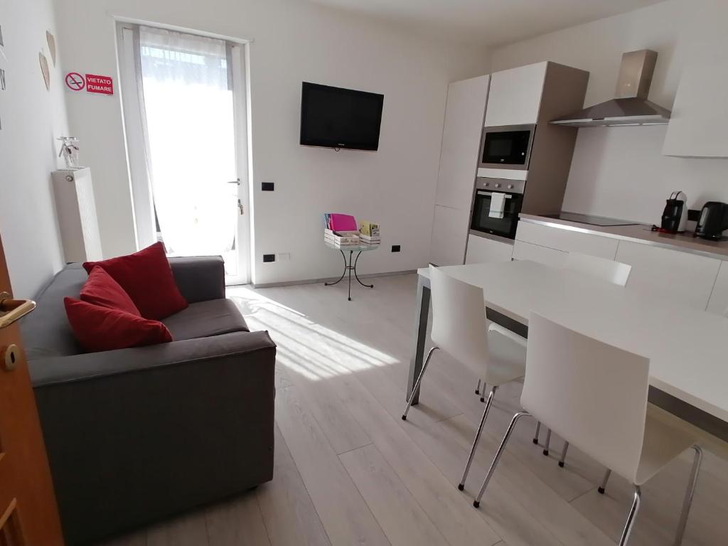 kuchnia i salon z kanapą i stołem w obiekcie Appartamento Meridiana w Arco