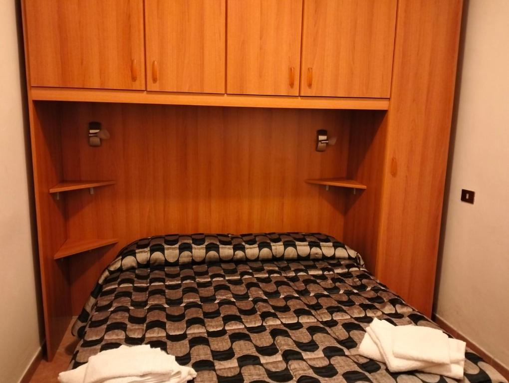 a bed in a room with wooden cabinets at La Bomboniera Cascia in Cascia