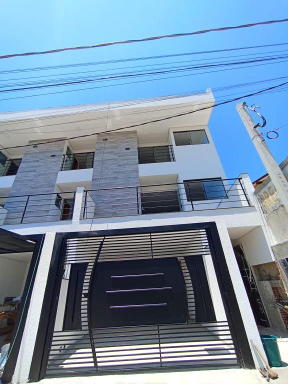 un edificio blanco con una puerta de garaje negra en Studio 23 vista para o mar en Pontal do Paraná