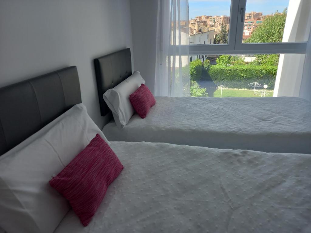 a bedroom with two beds and a window at POWER HOME in Granada