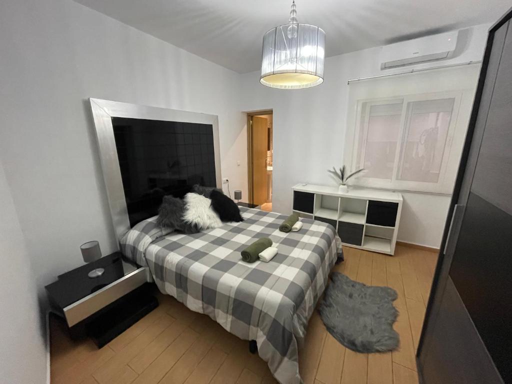 sypialnia z łóżkiem z kocem szachowym w obiekcie CASITA ANDALUZA CENTRO con PARKING sujeto a disponibilidad w Maladze