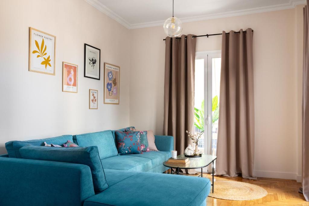sala de estar con sofá azul y mesa en Home of Petros, en Atenas