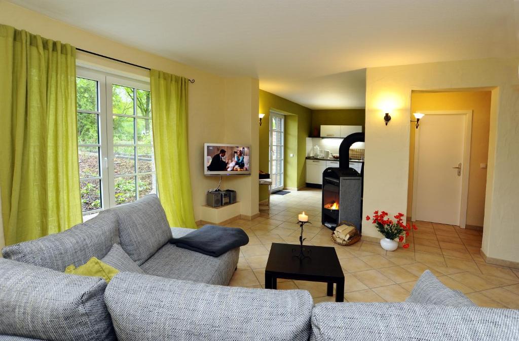 a living room with a couch and a tv at KASTANIENHOF im Spreewald in Burg