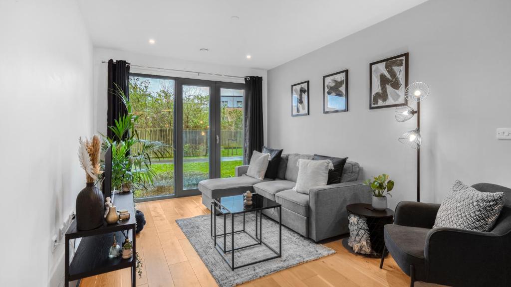 a living room with a couch and a chair at Axium Escape- 2 bed apartment, Birmingham City Centre in Birmingham