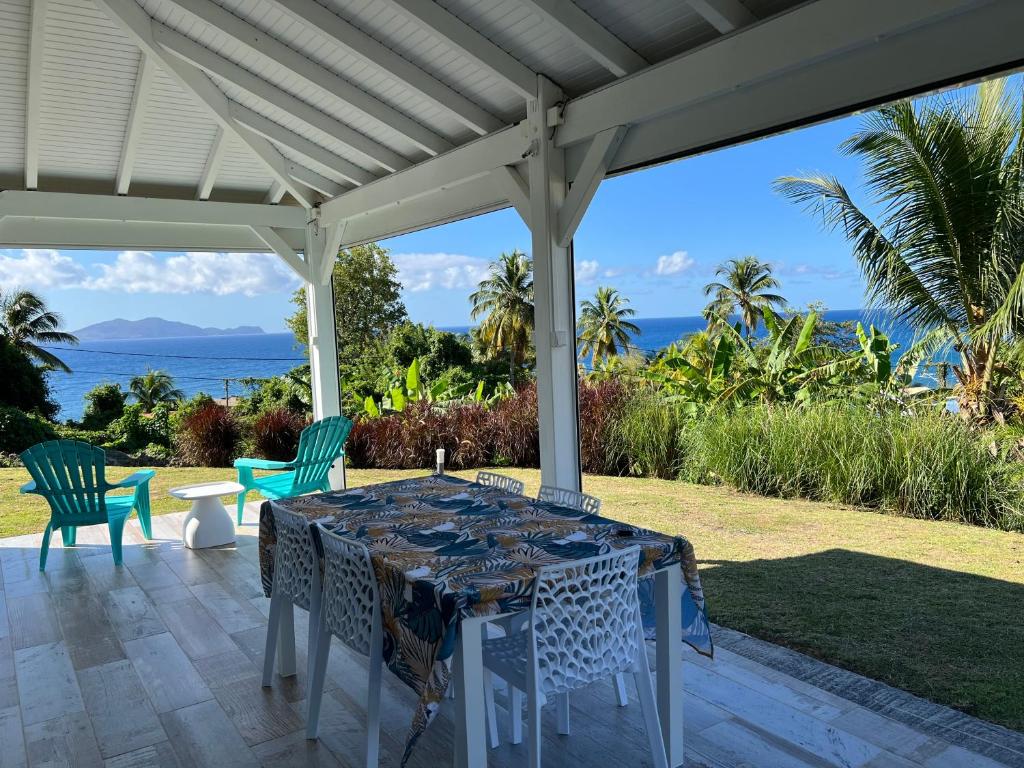 uma mesa e cadeiras num pátio com vista para o oceano em Villa OCEANE em Trois-Rivières