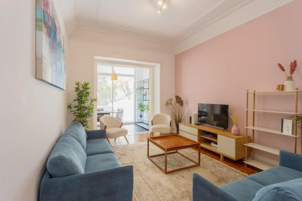 ein Wohnzimmer mit einem blauen Sofa und einem TV in der Unterkunft Charming Principe Real perfect for Families in Lissabon