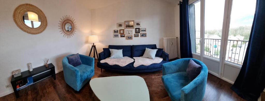 un salon avec un canapé bleu et deux chaises dans l'établissement Appartement avec vue panoramique sur les montagnes, au Bourget-du-Lac