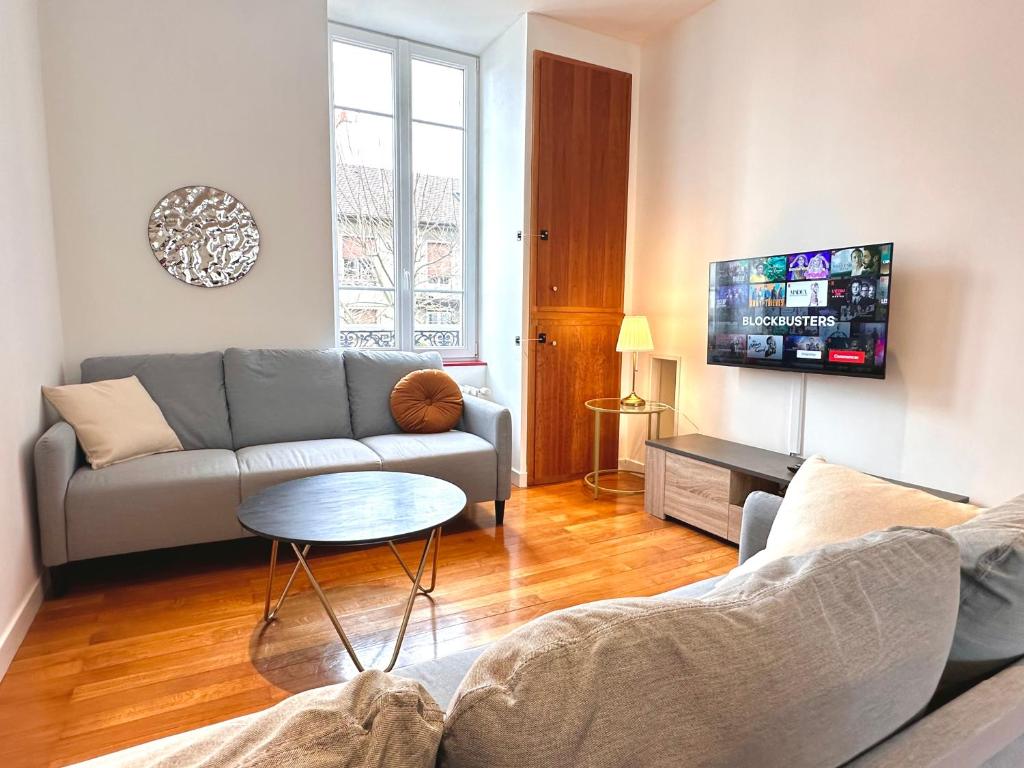 un salon avec un canapé et une table dans l'établissement La chouette de Dijon, à Dijon