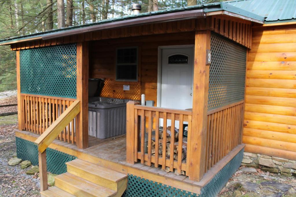 een grote houten hut met een veranda en een trap bij Hominy Ridge Cabins and Gift Shop in Sigel