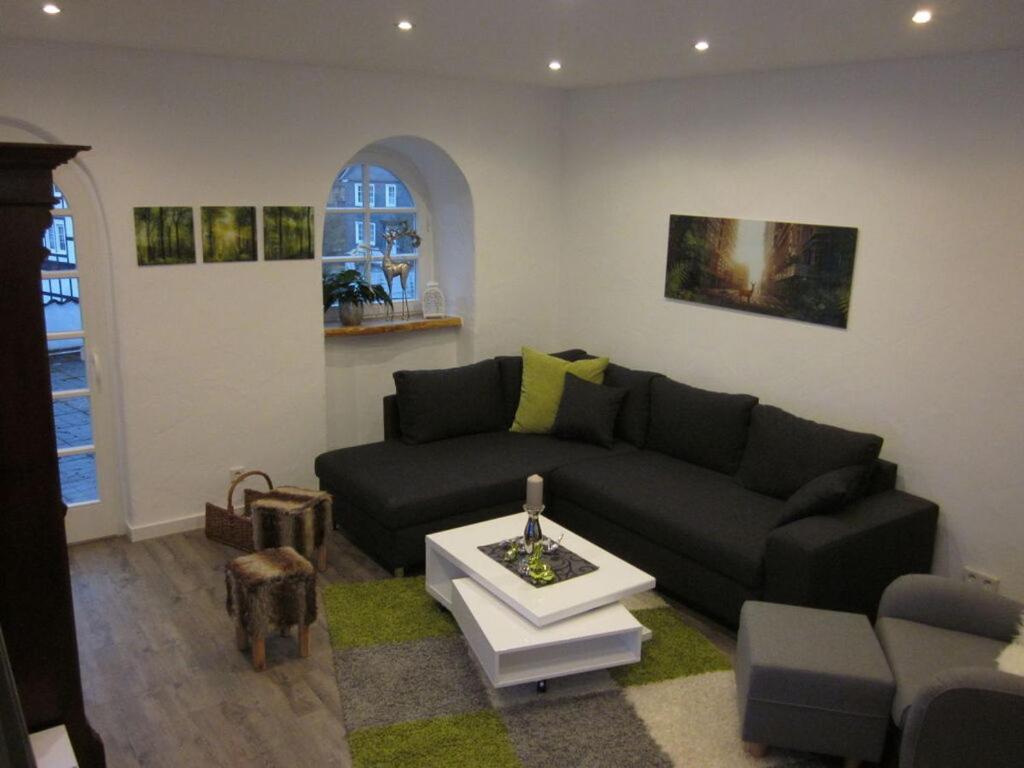 een woonkamer met een zwarte bank en een tafel bij Majestic apartment in Olsberg in Olsberg