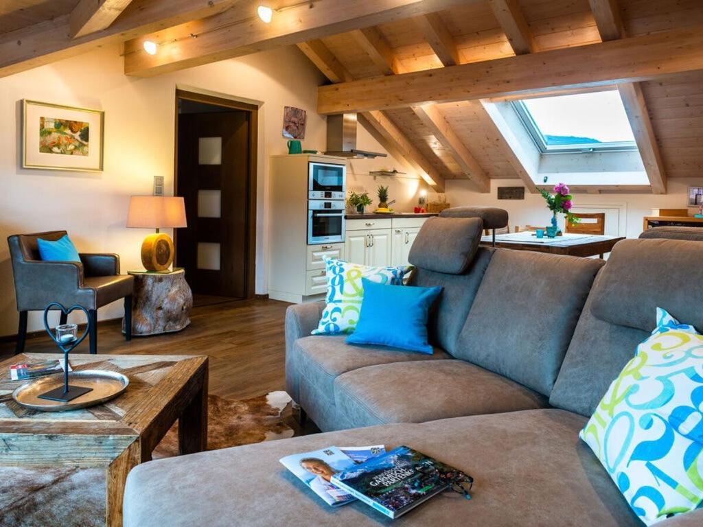 ein Wohnzimmer mit einem Sofa und einer Küche in der Unterkunft Apartment in Garmisch-Partenkirchen in Garmisch-Partenkirchen