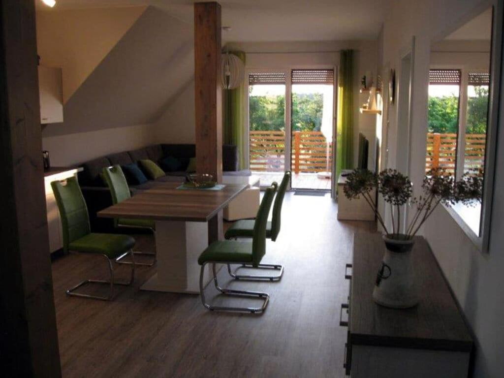 ein Esszimmer mit einem Tisch und grünen Stühlen in der Unterkunft Appealing apartment in Lübbenau in Lübbenau