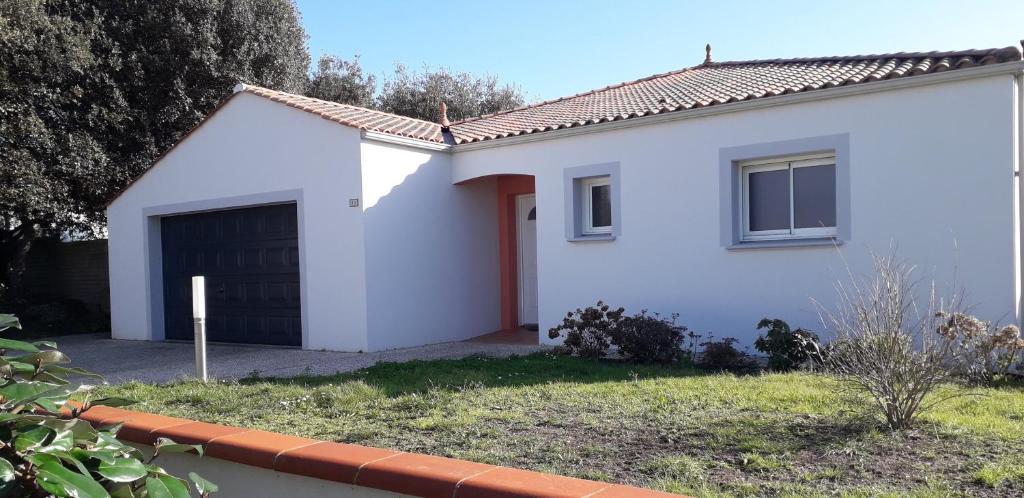 ein weißes Haus mit Garage in der Unterkunft La P'tite Etape in Talmont