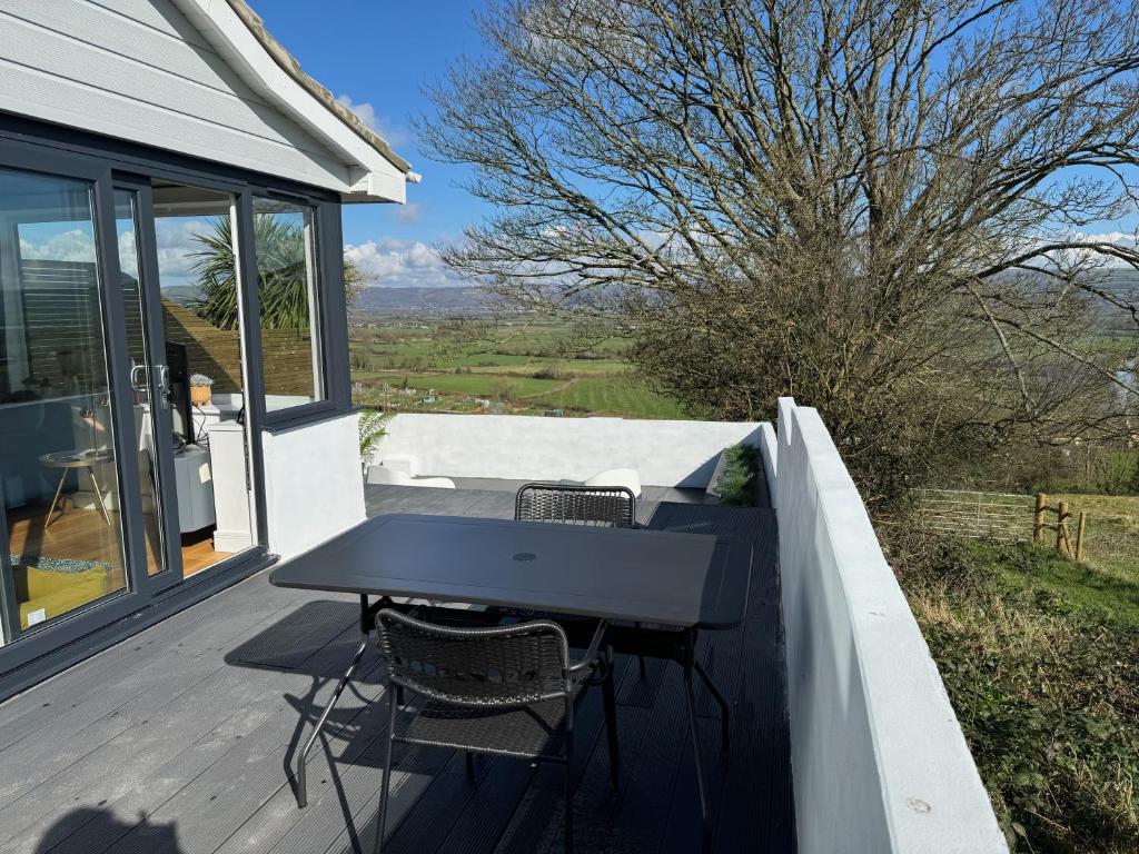 a table and chairs on a deck with a view at The Lookout in Wedmore