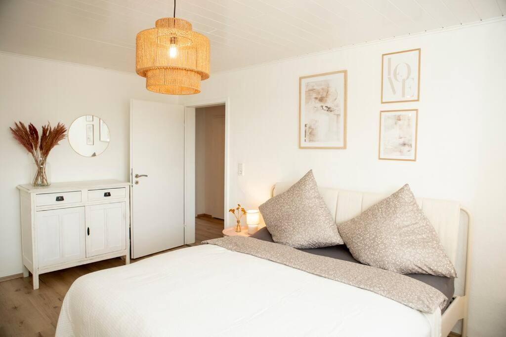 a bedroom with a white bed with two pillows at DESIGN:Suite am Festspielhaus in Recklinghausen