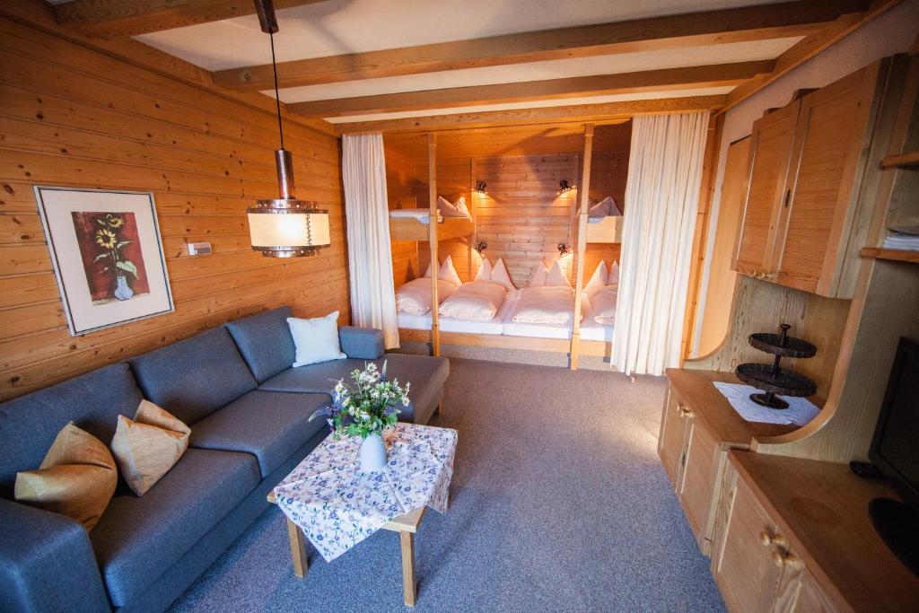 ein Wohnzimmer mit einem Sofa und einem Bett in der Unterkunft Ferienwohnung Jaufenthaler Zettersfeld in Lienz