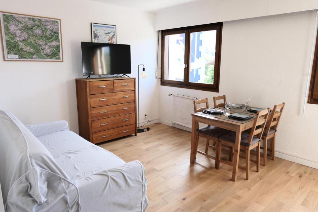 Cette chambre dispose d'une table, d'une télévision et d'un lit. dans l'établissement Résidence Les Dryades - Les Dryades 13 MAE-9564, à Saint-Gervais-les-Bains