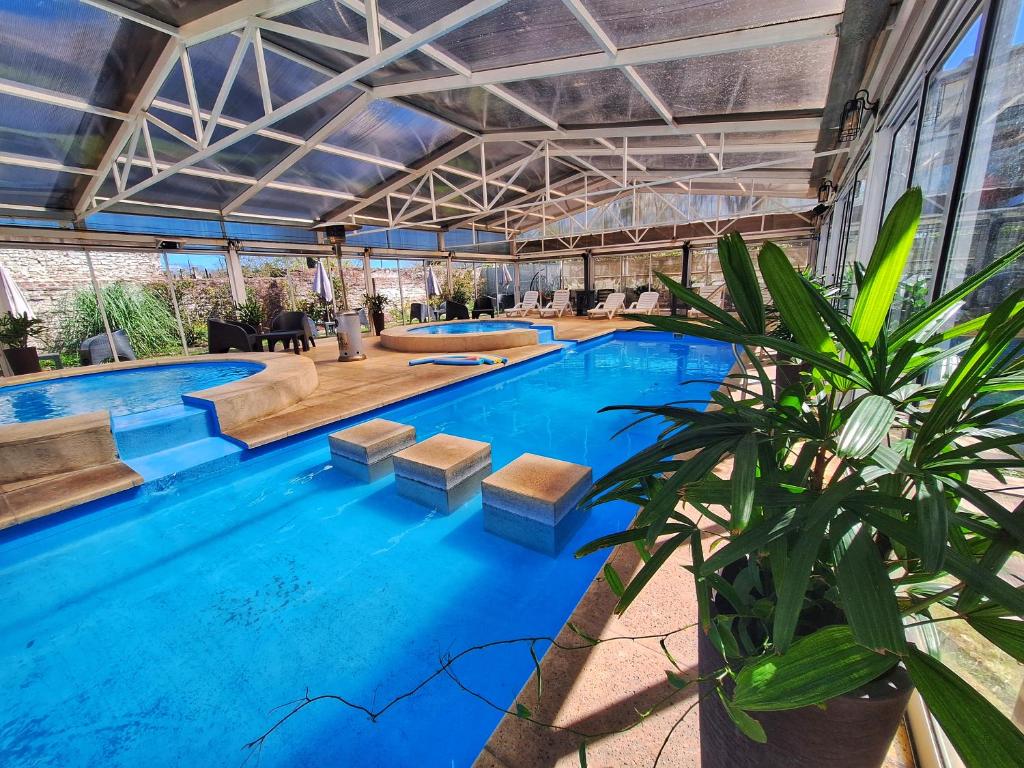 una gran piscina de agua azul en Atardeceres Apartments en Cañuelas