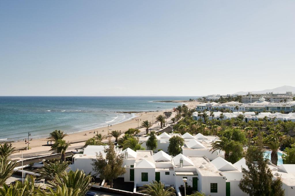 una vista aérea de una playa con casas blancas en Apartamentos LIVVO Las Gaviotas, en Puerto del Carmen