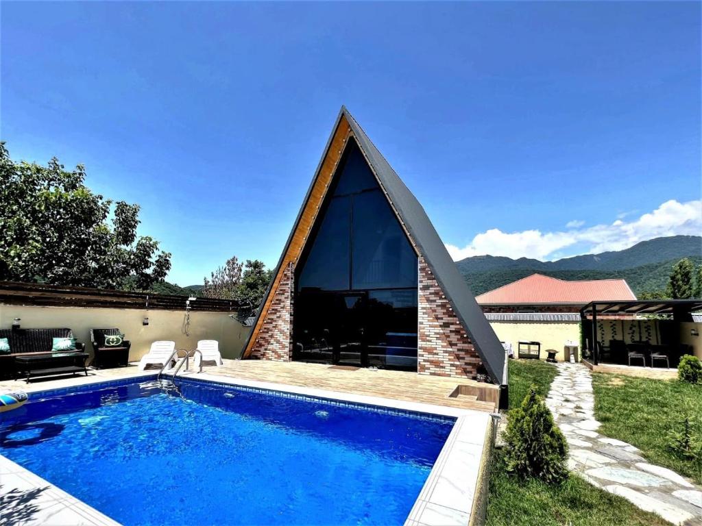 a house with a swimming pool with a triangular roof at Gabala Twin A Frame Villas in Gabala