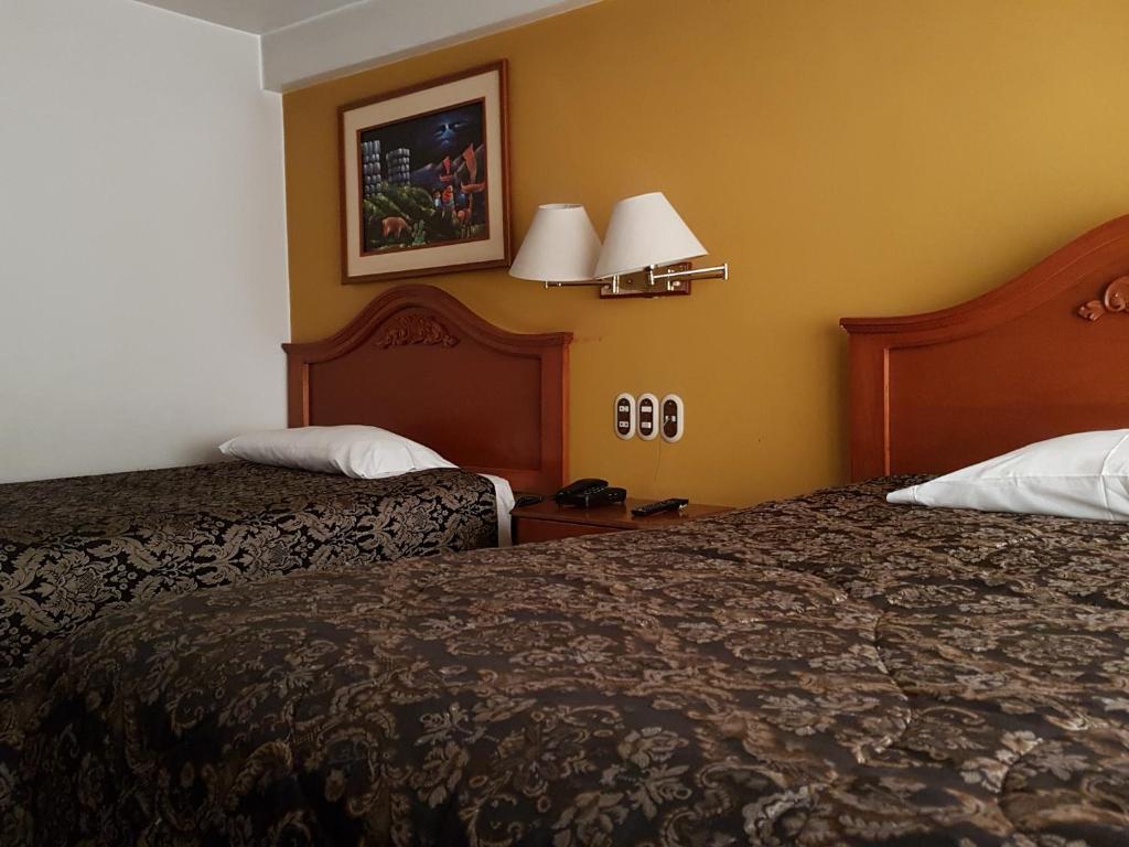 Habitación de hotel con 2 camas y 2 lámparas en CORONA, en Puno
