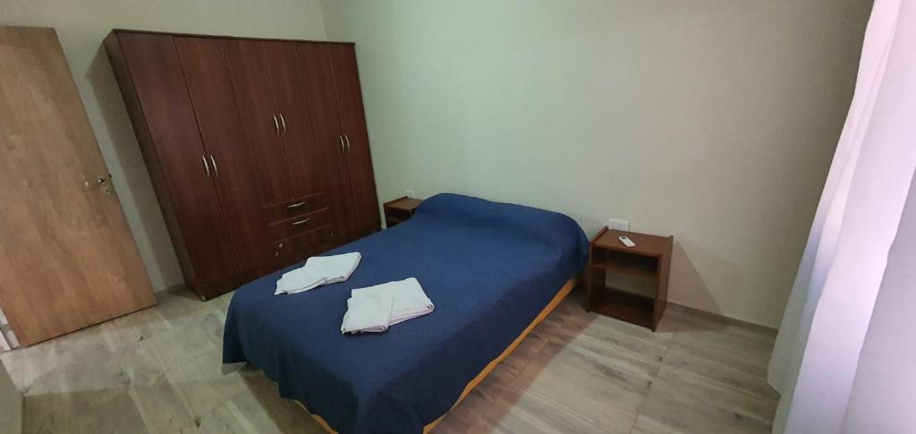 een slaapkamer met een blauw bed met 2 handdoeken erop bij Depto Catalina in Rafaela