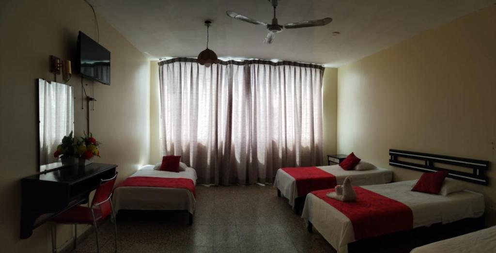 ein Hotelzimmer mit 2 Betten und einem Fenster in der Unterkunft Hotel Resident Piura in Piura