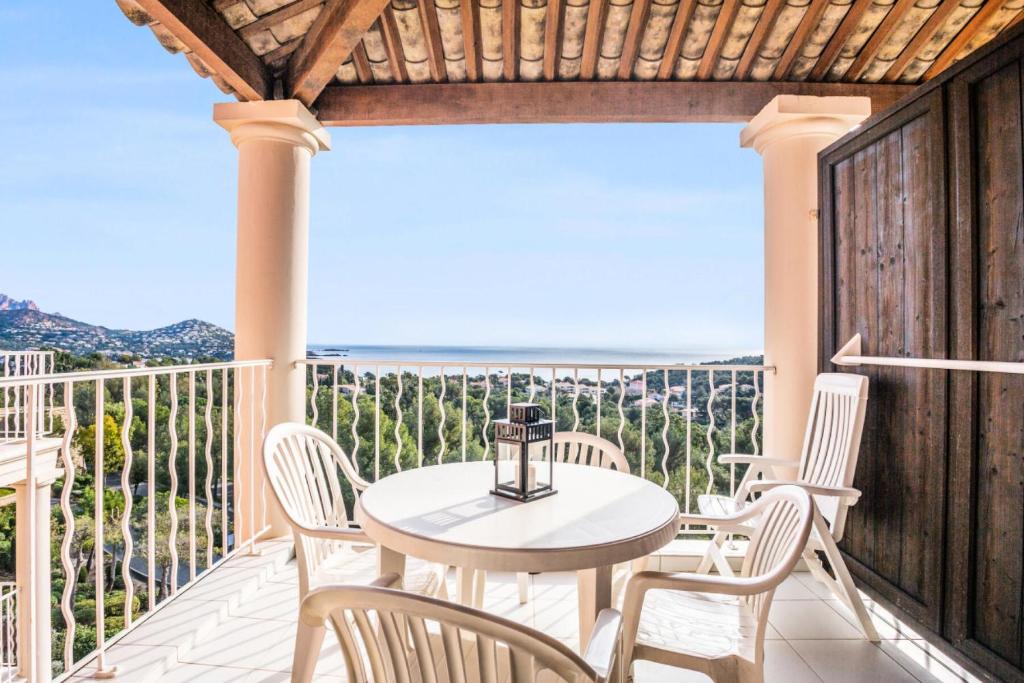 un patio avec une table et des chaises sur un balcon dans l'établissement Résidence le Hameau de Cap Esterel - maeva Home - Appartement 2 Pièces 5 Personnes - Sélection MAE-8433, à Saint-Raphaël