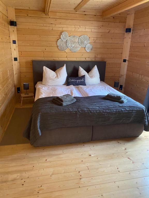 a bedroom with a large bed in a log cabin at Lodge-Altjeßnitz-Goitzsche 