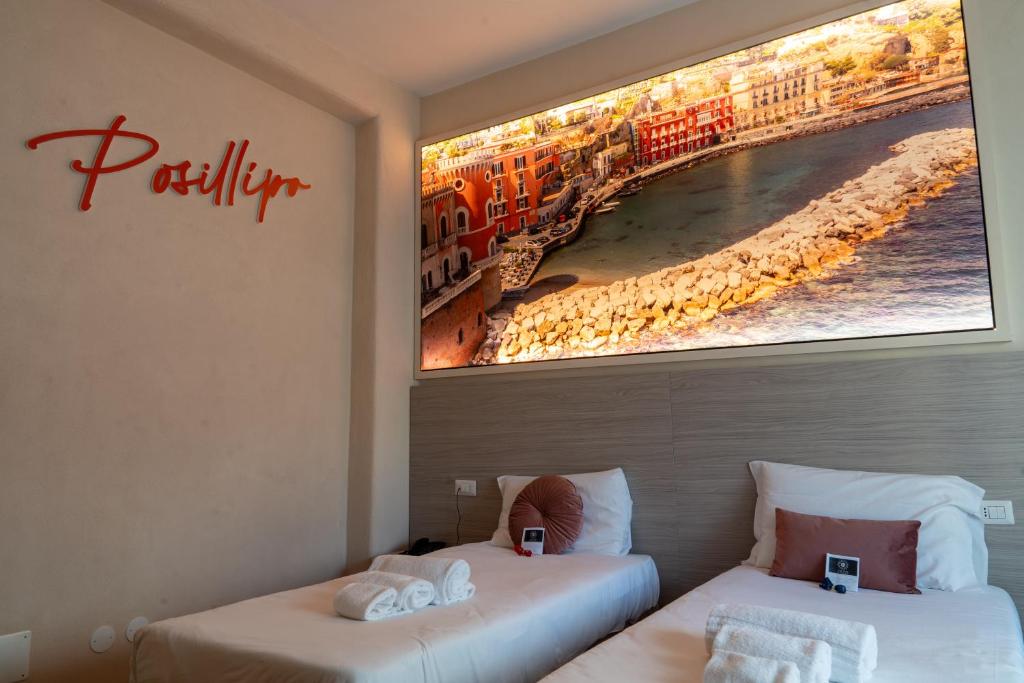 ナポリにあるTHE SUN HOTEL BOUTIQUE NAPOLIの壁に絵が描かれた部屋のベッド2台