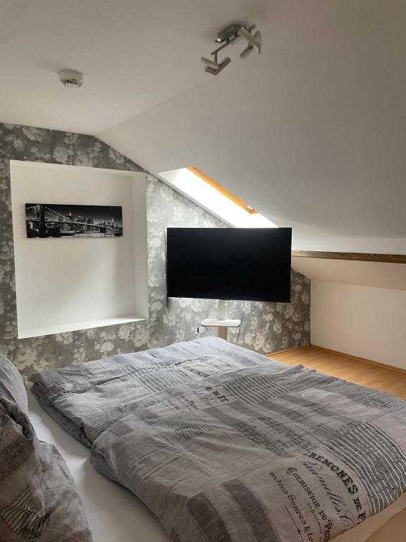 a bedroom with a bed with a flat screen tv on the wall at City View in Bodenwerder