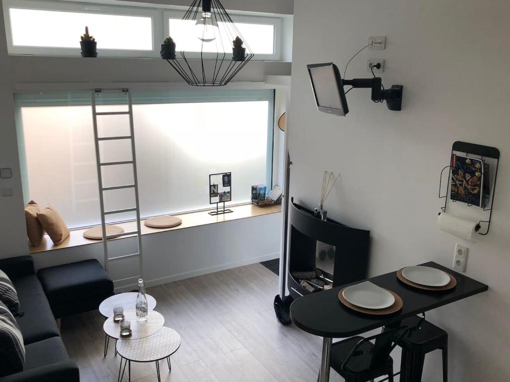 - un salon avec une échelle, une table et un canapé dans l'établissement Studio charmant au cœur de Clermont-Ferrand, 30 m², cheminée, à Clermont-Ferrand