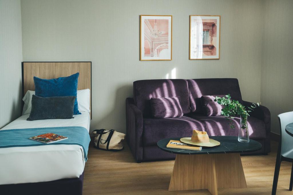 sala de estar con sofá y mesa en The Oliver Apartamentos Aravaca, en Madrid