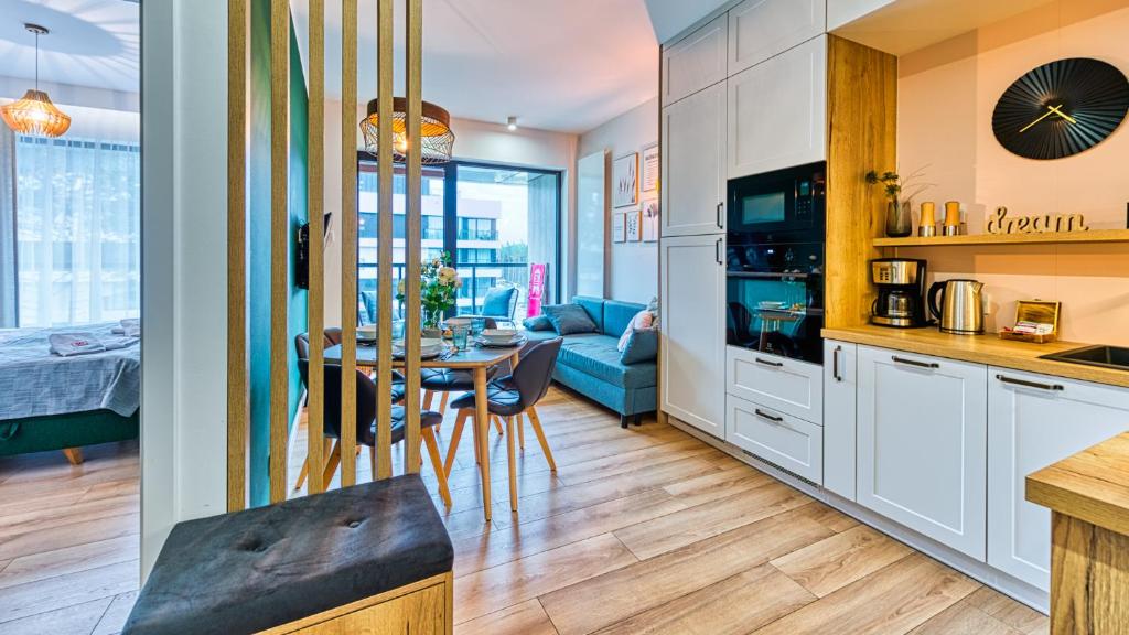 uma cozinha e sala de estar com uma mesa e um sofá em Apartament Schellter 62 przy Wydmach - by 5D Apartamenty em Rogowo